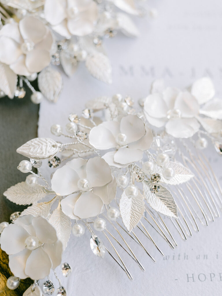 The White Collection bridal hair accessory with pearls laying on the wedding invitation