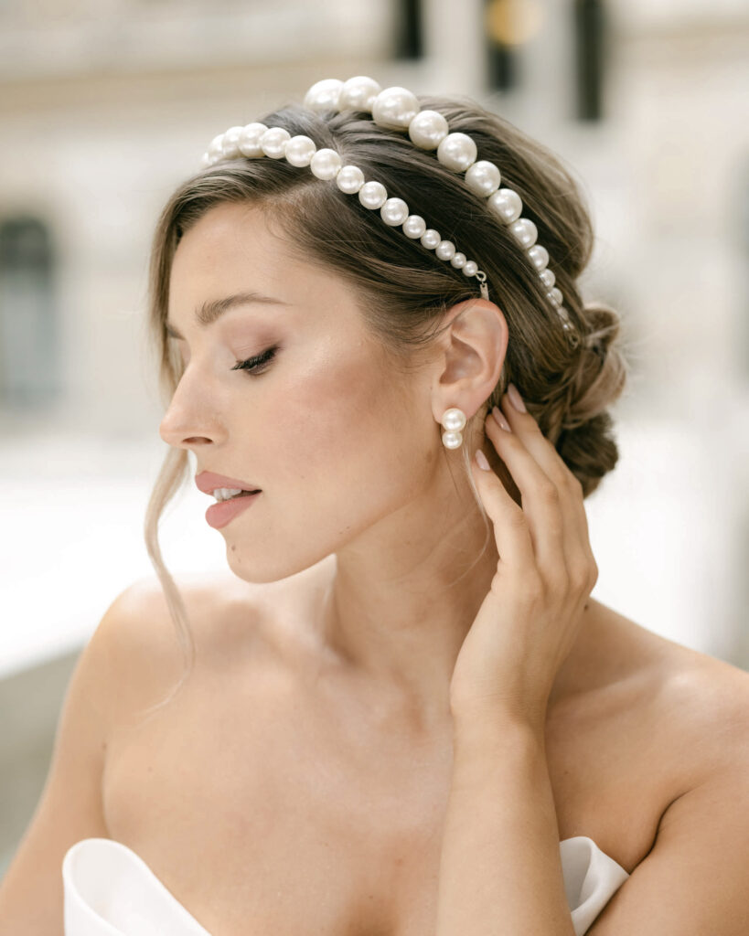 Bride wearing double pearl headband and pearl earrings